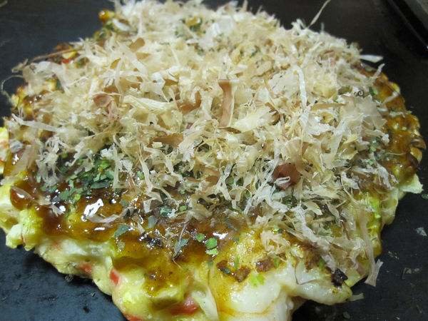 Japanese food:Okonomiyaki. Okonomiyaki are savory Japanese pancakes filled with meat, seafood and vegetables. They can be topped with mayonnaise, katsuobushi, n